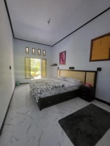 a bedroom with a bed and a large window at Exotic Backpackers in Banyuwedang