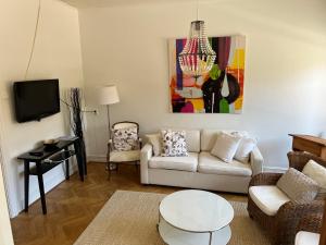 a living room with a couch and a table at Villa Brigitta, havsnära boende mittemot Klostret i Ystad centrum in Ystad