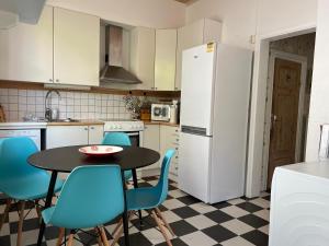 a kitchen with a table and chairs and a refrigerator at Villa Brigitta, havsnära boende mittemot Klostret i Ystad centrum in Ystad