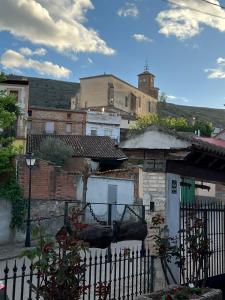 um grupo de edifícios com uma cerca e uma casa em Apartamentos Rurales El Pedregoso 