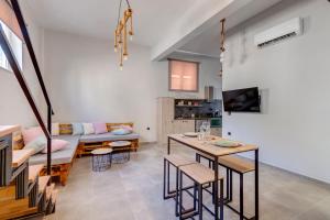 a living room with a table and a couch at LUNA & TERRA APARTMENTS SYROS in Ermoupoli