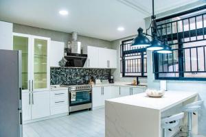 a kitchen with white cabinets and a stove top oven at Y-twin apartments in Yaoundé
