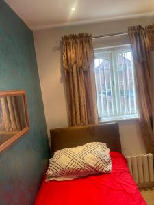 a bedroom with a red bed with a window at Jules Homestay Plus in Ocker Hill