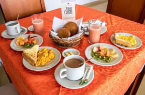 a table topped with plates of food and cups of coffee at Nogal Suite Hotel Ipiales in Ipiales