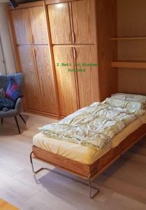 een bed in een kamer met een kast en een stoel bij Modernes Wohlfühlstudio im Haus Eldorado mit Traumaussicht in Leukerbad