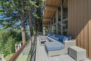a deck with a couch and a table on a house at All About the Lake by NW Comfy Cabins in Leavenworth