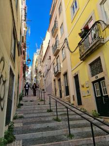 Un groupe de personnes marchant dans une rue avec des escaliers dans l'établissement Heart of Lisbon - Bica Apartamentos, à Lisbonne