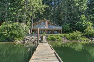a house on the water with a wooden dock at All About the Lake by NW Comfy Cabins in Leavenworth