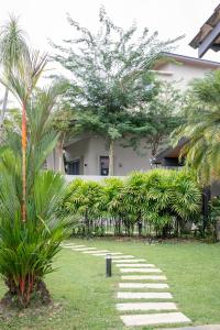 a garden with a stone path in front of a building at Kontor Mansion - 3 mins to Teluk Chempedak Beach & Private Pool in Kuantan