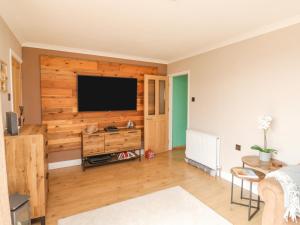 a living room with a flat screen tv on a wooden wall at Terrace Views in Torquay