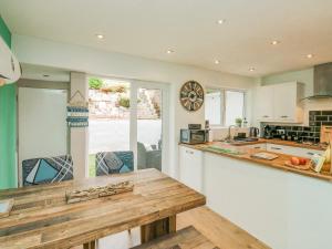 a kitchen with a wooden table and a counter top at Terrace Views in Torquay