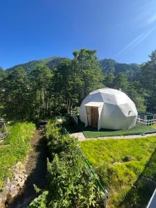 una tienda blanca en un campo con montañas al fondo en Ayder Freedome en Ayder Yaylasi