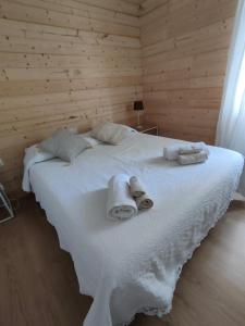 1 dormitorio con 1 cama blanca grande y toallas. en Piccolo Appartamento Casa Vacanze B&B Angela, en Clusone