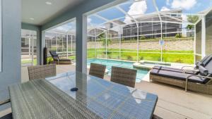 une terrasse avec une table et des chaises ainsi qu'une piscine dans l'établissement Luxury 6 Bedroom Vacation Home, à Davenport