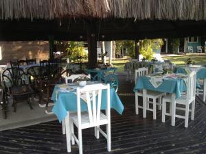 a group of tables and chairs with blue and white tables at Pousada Canto da Galheta in Ilha do Mel
