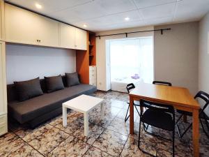 sala de estar con sofá y mesa en Apartamento loft en Castelldefels junto la playa, en Castelldefels