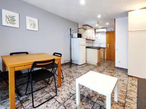 cocina y comedor con mesa de madera y sillas en Apartamento loft en Castelldefels junto la playa, en Castelldefels