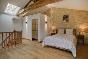 a bedroom with a bed and a wooden floor at La Maronniere in Challignac