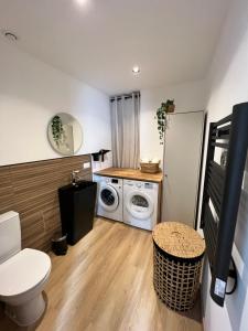 een wasruimte met een wasmachine en droger bij L’Eden d’Opale in Coquelles