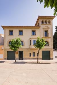 un edificio con dos árboles delante de él en Torre Chiguita, en Tarazona de Aragón