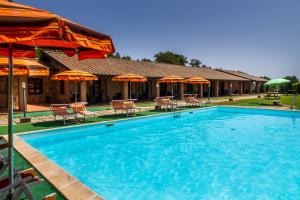 een groot zwembad met parasols en stoelen bij Casa Vacanza Il Carpignone 7 in Massa Marittima