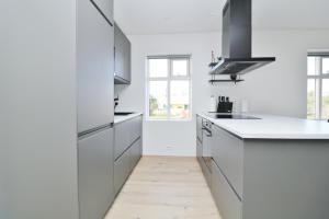 a white kitchen with white counters and a window at LL Properties - G7 Luxury House By The Harbor in Akureyri