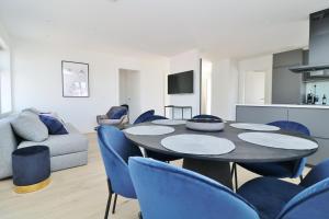 een woonkamer met een tafel en blauwe stoelen bij G7 Akureyri Central Apartments in Akureyri