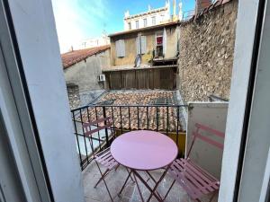 a pink table and chairs on a balcony at Pleasant 3-bedroom flat in the center of Marseille in Marseille