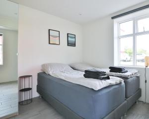 a bed in a white room with two bags on it at G7 Akureyri Central Apartments in Akureyri