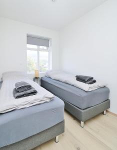 two twin beds in a room with a window at LL Properties - G7 Luxury House By The Harbor in Akureyri +27 photos