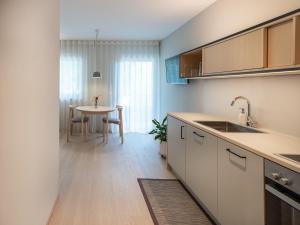 a kitchen with a sink and a table at Dianthus Apartment in Lana