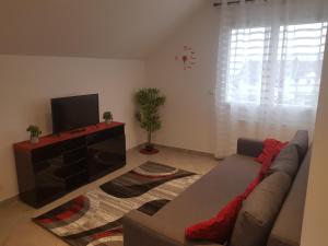 ein Wohnzimmer mit einem Sofa und einem Flachbild-TV in der Unterkunft APPARTEMENTS NEUFS PROCHE DE PARIS in Bonneuil-sur-Marne