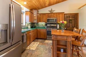 - une cuisine avec des placards en bois, une table en bois et un réfrigérateur dans l'établissement Secluded Oasis on Acadia's Quietside - Pets OK!, à Southwest Harbor