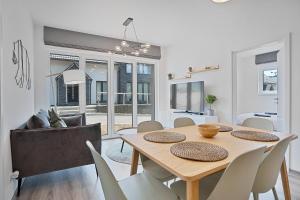 a dining room and living room with a wooden table and chairs at Mirabel Apartments Klinovec in Loučná pod Klínovcem