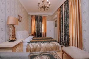 a bedroom with a bed and a desk and a lamp at Tbilisi My House in Tbilisi City