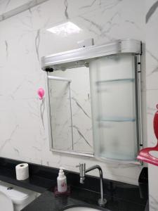 a bathroom with a sink and a mirror at Apartamento Pé na Areia - Praia Grande - SP, Aviação in Praia Grande