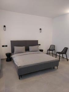1 cama grande en una habitación con 2 sillas en בית דירות - בית אורן, en Beit She'an