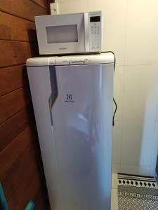 a microwave sitting on top of a refrigerator at Refúgio Allamanda Flats in Visconde De Maua