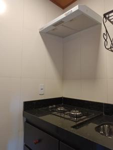 a kitchen with a stove and a sink at Refúgio Allamanda Flats in Visconde De Maua