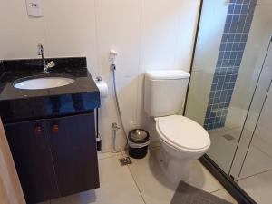 a bathroom with a toilet and a sink and a shower at Refúgio Allamanda Flats in Visconde De Maua