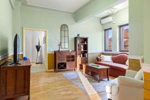 a living room with a couch and a tv at City Heart Retreat Elegant Apartment in Bucharest