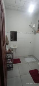 a white bathroom with a sink and a tv on the wall at Bonserá do Madeira in Lavras