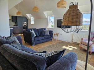 a living room with blue couches at Hillside House in Elgol