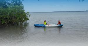 dwoje ludzi w niebieskim kajaku w wodzie w obiekcie Coco Key EcoLodge - Breakfast - Sea w mieście Bocas del Toro