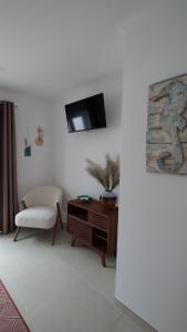 a living room with a chair and a tv on a wall at Casa da Torre - A Gema Escondida da Tavira in Tavira
