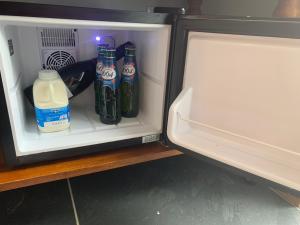 een open koelkast met flessen melk en sap bij Trewethen Cottage Barn 1 near Port Isaac in Port Isaac