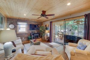 a living room with white furniture and a ceiling fan at Lakefront Cottage with Deck Near Indiana Beach! in Monticello