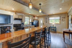 a kitchen with a long bar with stools at Lakefront Cottage with Deck Near Indiana Beach! in Monticello +22 photos