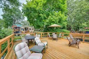 a wooden deck with chairs and tables and an umbrella at Lakefront Cottage with Deck Near Indiana Beach! in Monticello