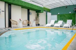 a swimming pool with chairs and a table at Ker Recoleta Hotel in Buenos Aires